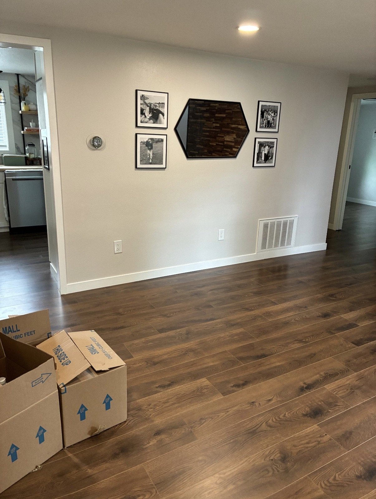 Freshly painted living area with new laminate flooring and baseboards