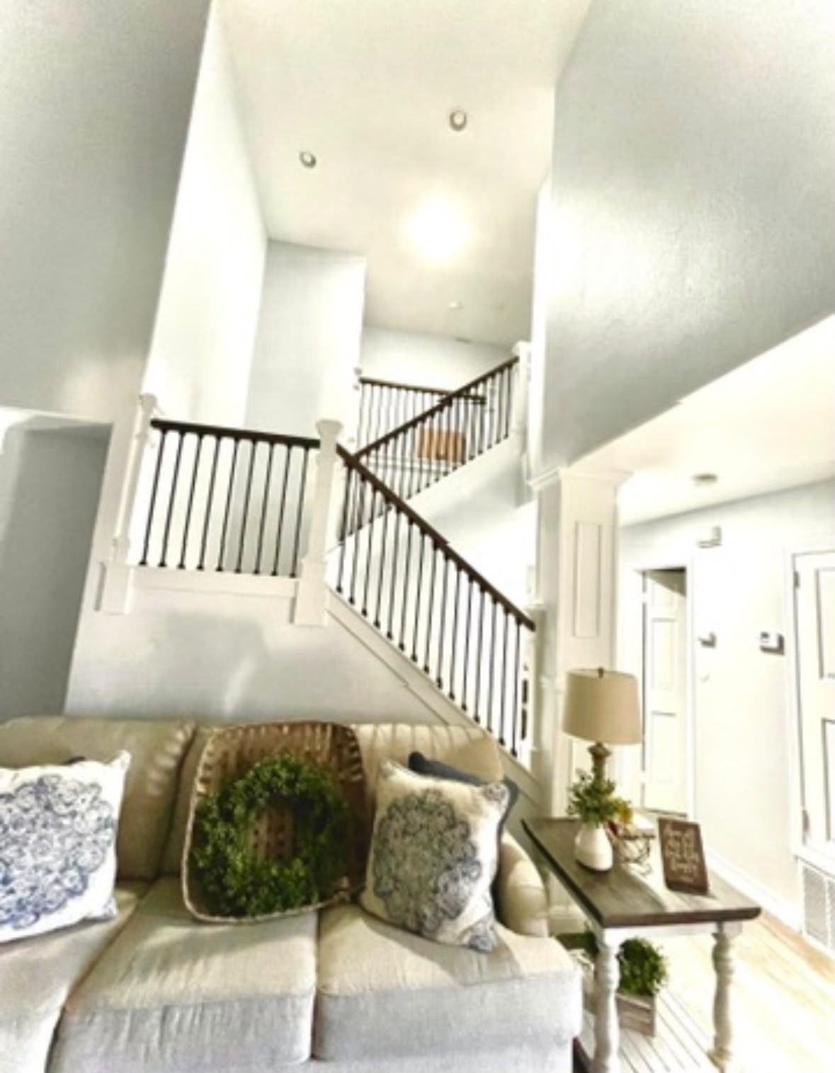 Bright two-story living room and stairway with iron balusters and fresh paint