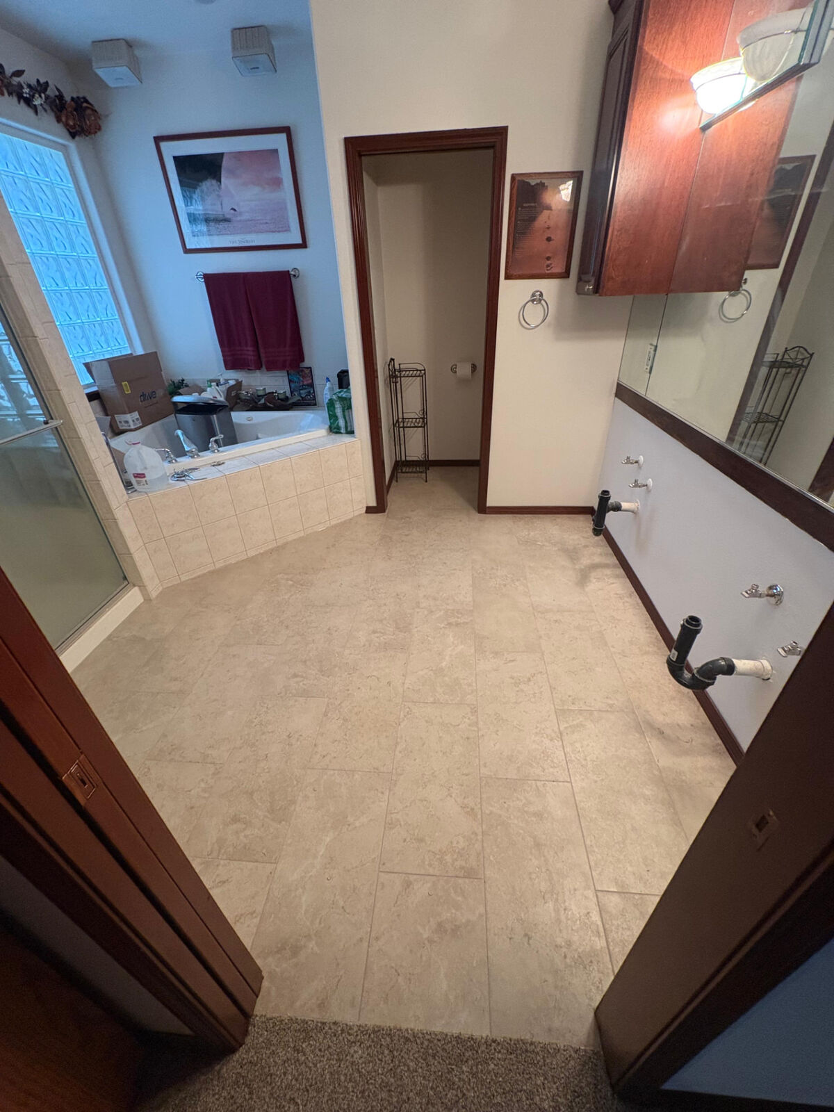 Finished primary bathroom with new tile flooring and stained trim