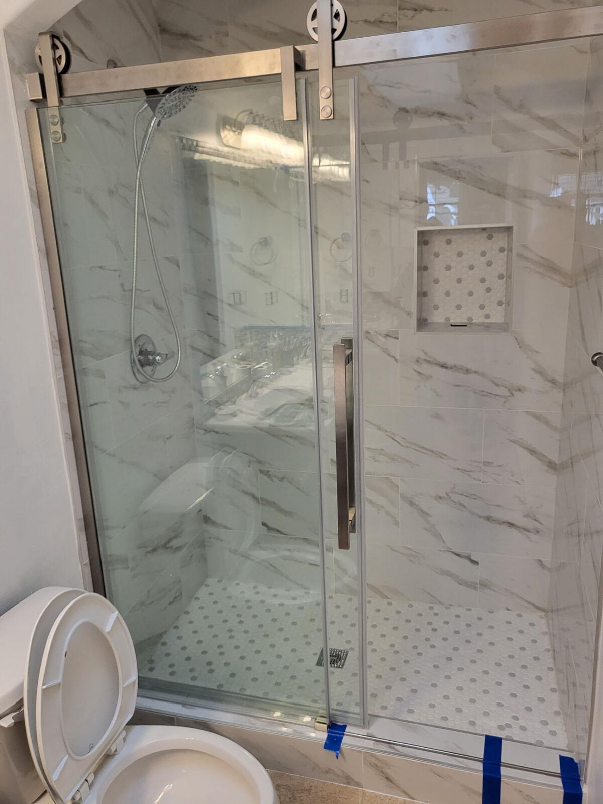 White marble-look shower with sliding glass door